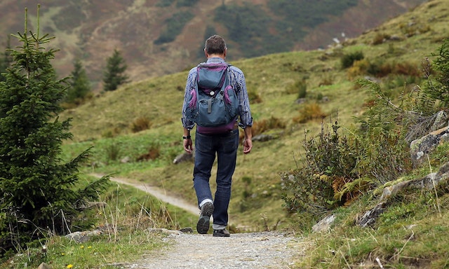 Hombre caminando por un sendero boscoso